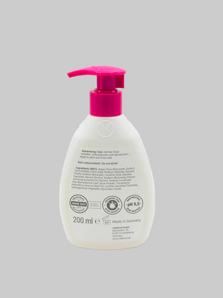 White bottle with a pink pump on a gray background