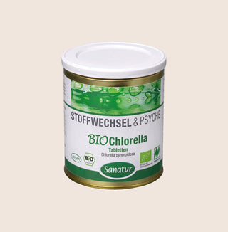 Canister of BIO Chlorella tablets with a white and green label on a beige background
