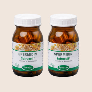 Two bottles of Spermidin Spirucell Sanatur on a beige background