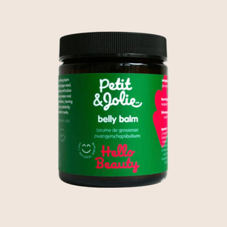 Petit Jolie belly balm jar with green label on a beige background